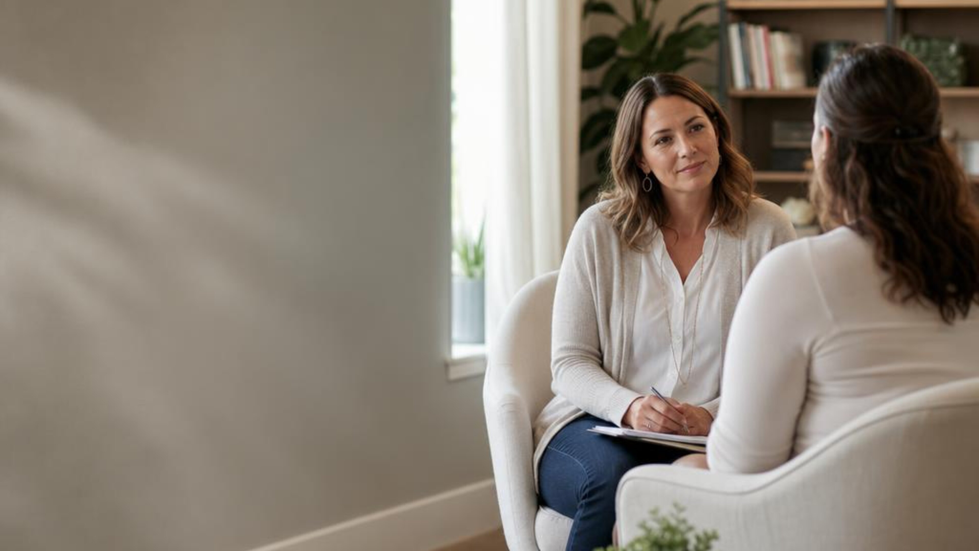 Two adults having a compassionate conversation in a warm office, illustrating eating disorder support. Generated illustration, not actual patients or clinic staff.